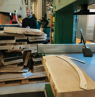 Man guide standing near wood pieces in a workshop, Stolab Factory