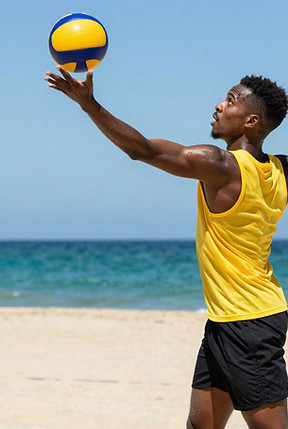 Man hitting volleyball on a beach for a league game