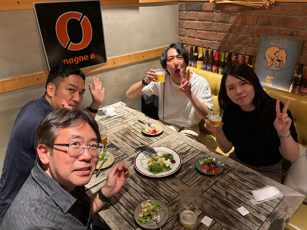 社内イベントの食事をしている最中にカメラを向けられてポーズを決める男女4人