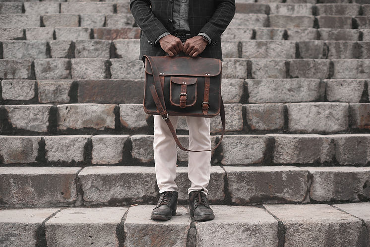 man-holding-a-leather-bag-on-a-set-of-st