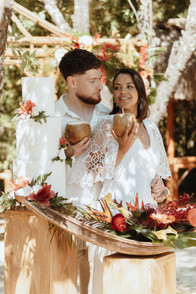 photo de couple mariés devant le wedding cake tropical et coloré