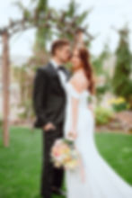 Bride and groom under arch in embrace