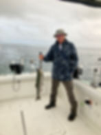 lake ontario fishing charters man holding fish up by wire