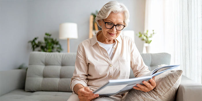 Elderly woman reading a brochure.