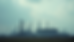 Eye-level view of oil refinery with storage tanks under cloudy sky