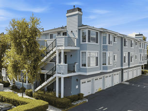 Front exterior view of 23412 Pacific Park Dr #29C, a top-level single-story condo for sale in Aliso Viejo, CA 92656, featuring a private entry balcony, panoramic mountain views, and convenient covered access to a one-car garage.