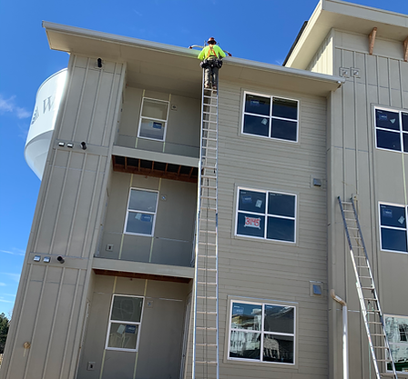 gutter installer on a three story apartment complex installing gutter