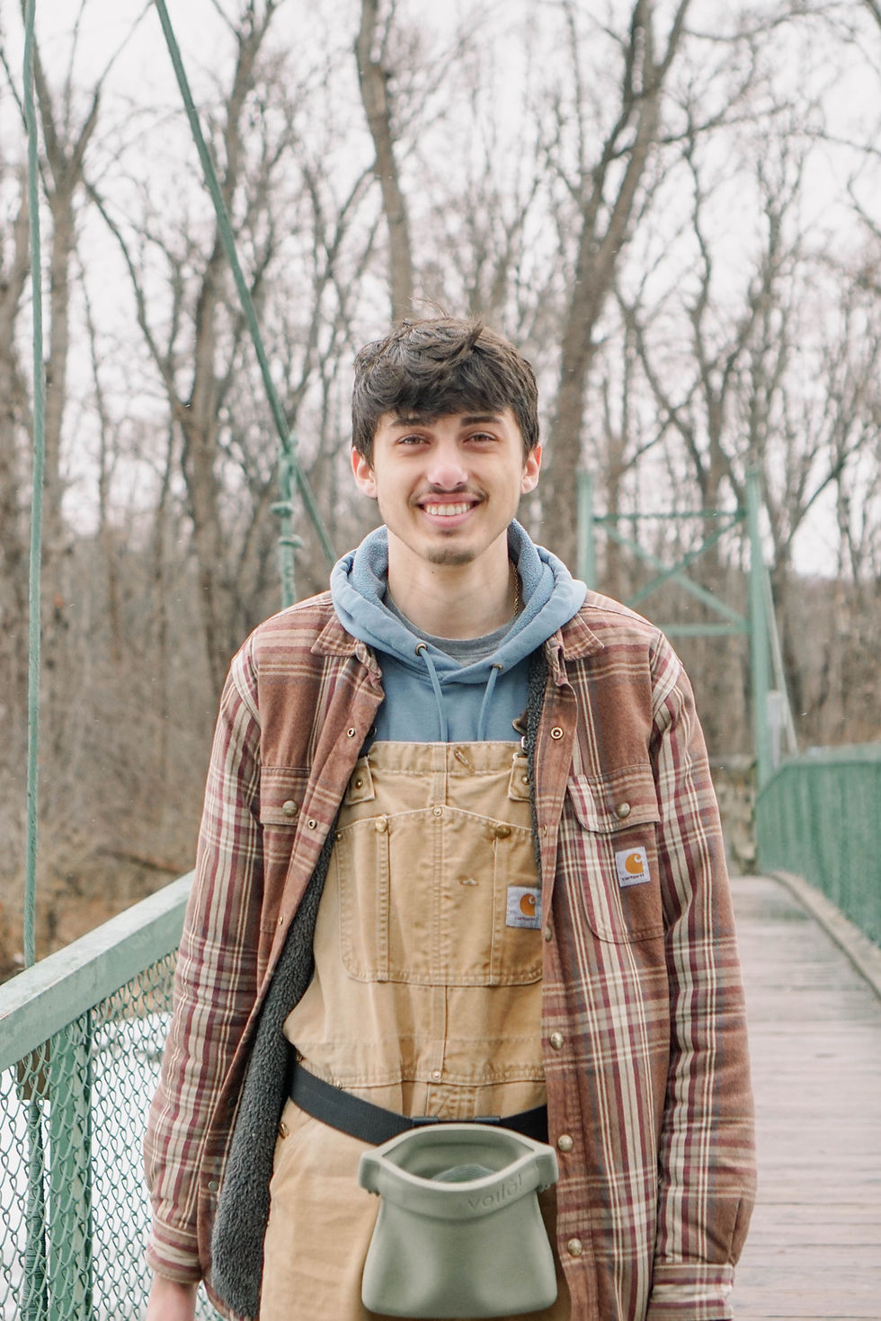 Ryan Anderson, owner and education-based dog trainer at RMA Canine, standing on a footbridge near Binghamton, NY