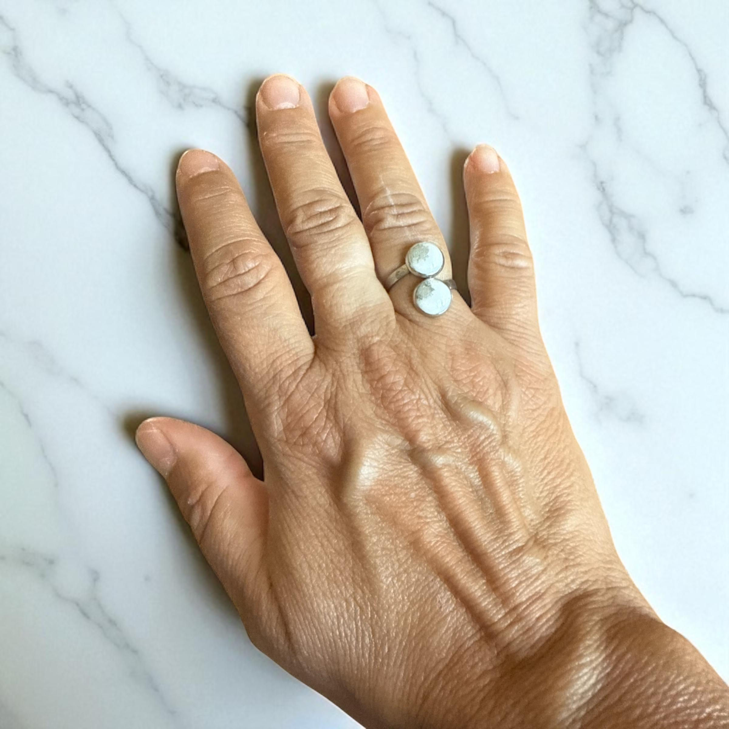 Anello doppio con pietra chiara su mano