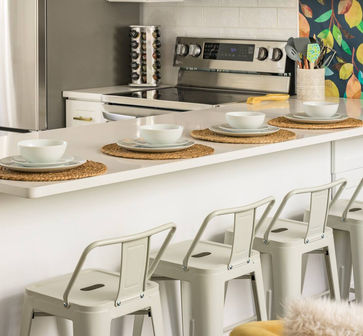 Fully equipped kitchen at The June House with sleek countertops, stainless steel appliances, and a counter dining.