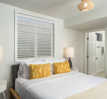 Elegant bedroom at The June House with a plush Queen-size bed, soft linens, and attached bathroom. 