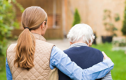 Young carer walking with the elderly woman in the park