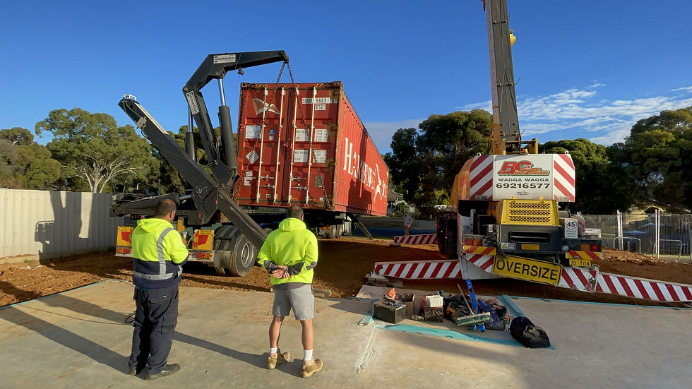 A red shipping container unloaded via a side loader.
