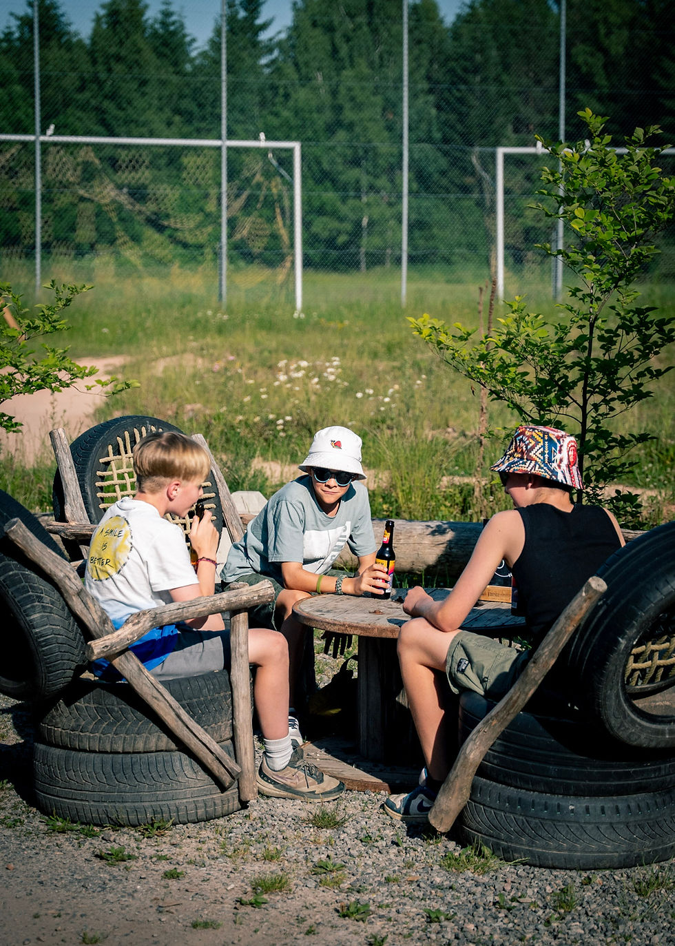 Drei Jungs sitzen auf Stühlen der Kartanlage