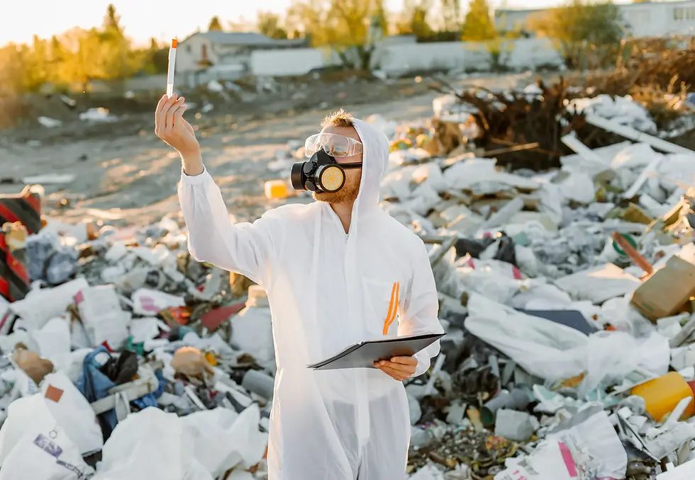 Technicien en combinaison de protection réalisant un prélèvement sur une ancienne décharge polluée