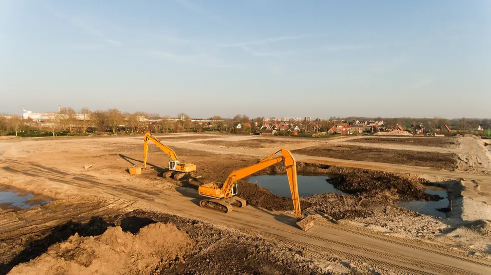 Deux pelles mécaniques excavant des terres sur un vaste chantier de terrassement, avec eau de fouille visible, illustrant la gestion des matériaux d'excavation sur un site pollué