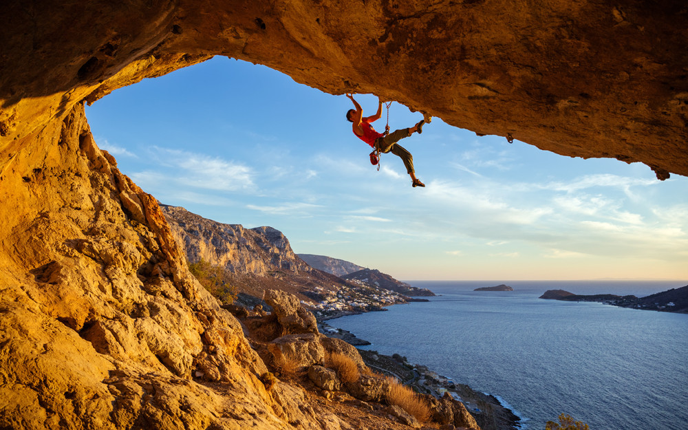 Rock climber on crag above the sea. Rock climbing presents wilderness safety and outdoor risk management concerns, but real risks are low if climbing is managed well.