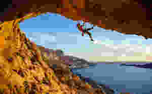 Rock climber on crag above the sea. Rock climbing presents wilderness safety and outdoor risk management concerns, but real risks are low if climbing is managed well.
