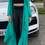 Miniaturbild: Modell in türkisfarbenem Ayla Kimono und schwarzer Leggings vor einem Luxusfahrzeug.