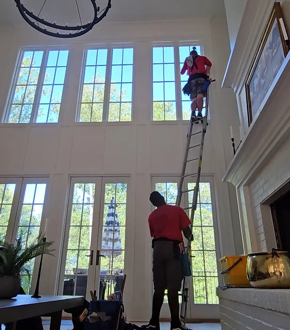 Two professional window cleaners working on an old house in Georgia
