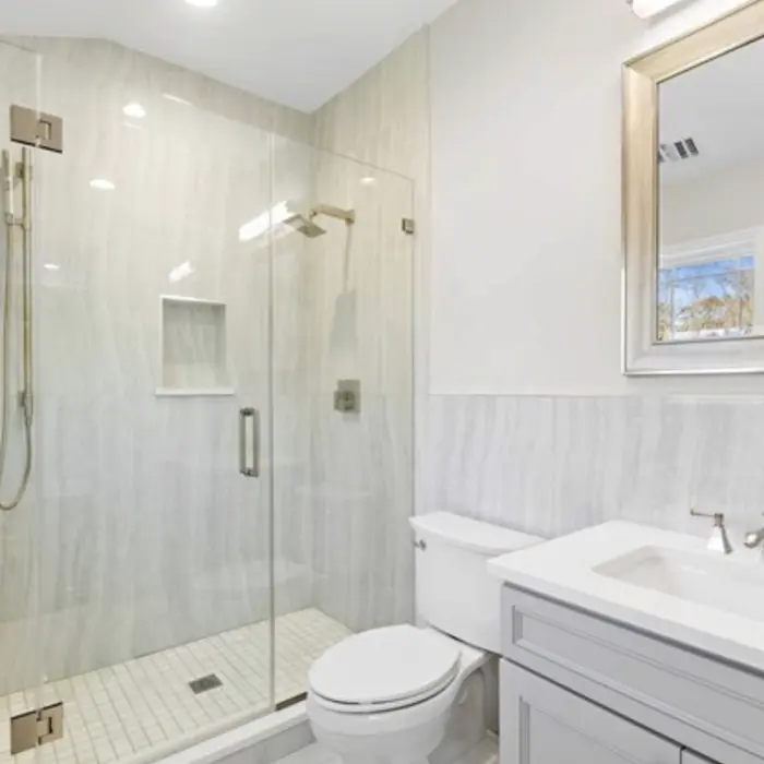 Modern bathroom with wood vanity, round mirror, and built-in bathtub