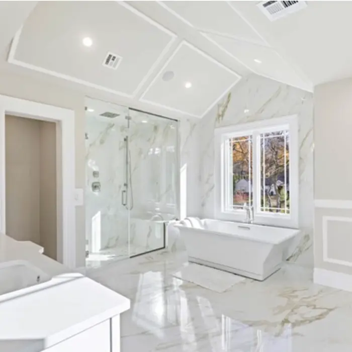 Luxurious white bathroom with marble floors, freestanding tub, and glass-enclosed shower