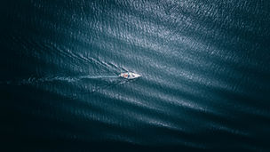 A boat gliding across a dark blue ocean