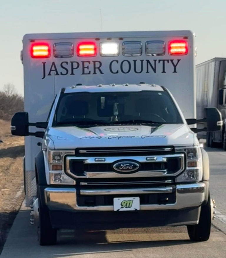 Front view of a Jasper County EMS ambulance with lights on