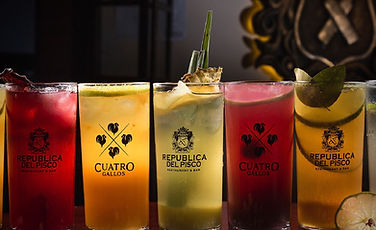 Selezione di cocktail colorati di pisco, bevanda nazionale del Perù, serviti in un bar che promuove la cultura del bere consapevole e supporta l'artigianato locale.