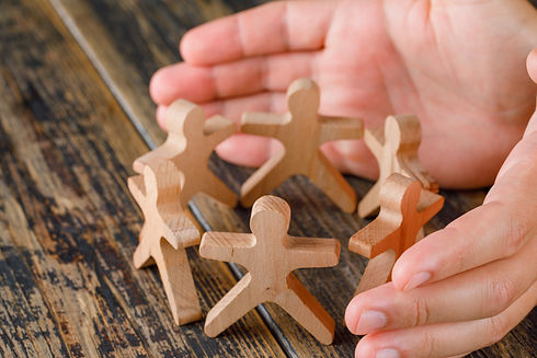 business-success-concept-wooden-table-top-view-hands-protecting-wooden-figures-people.jpg