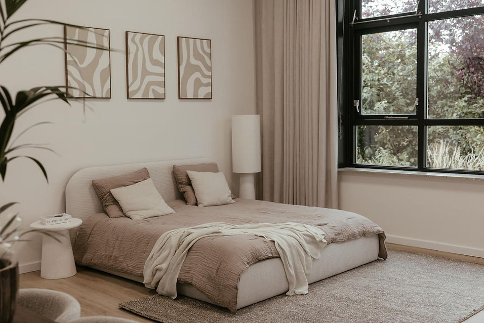 Landschapsfoto van een rustige slaapkamer in beige tinten met groot raam