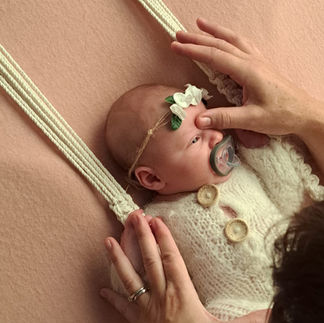 soothing a newborn in a white suit