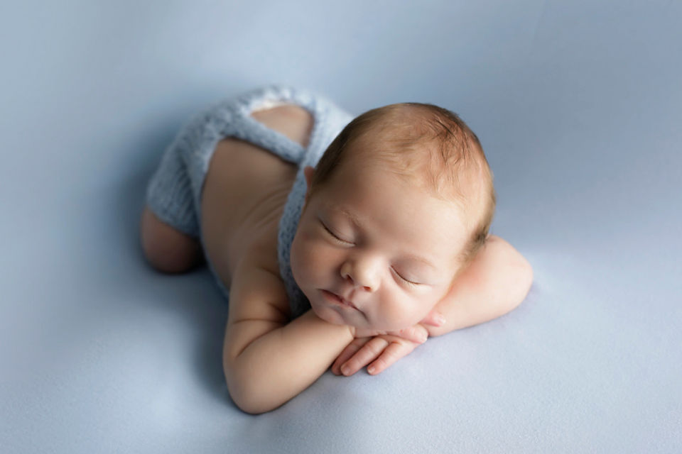 newborn boy in dungerees