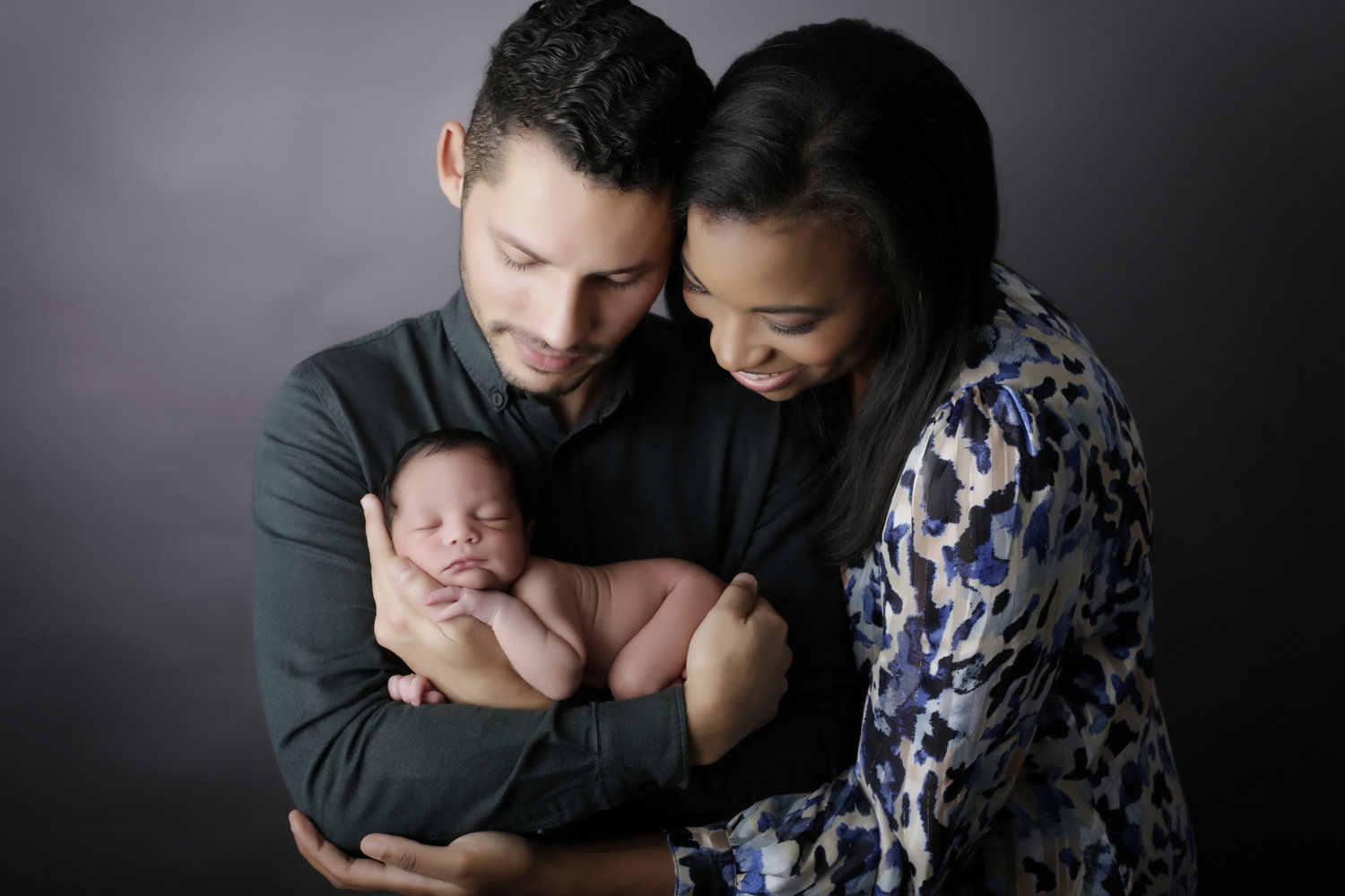 newborn boy being cradled by his parents