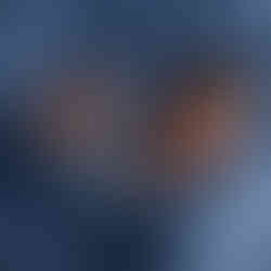 wrapped newborn holding teddy lying on a matching blue flokati