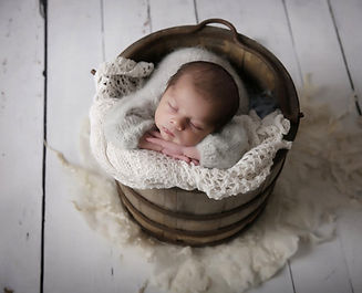 newborn in wooden bucket