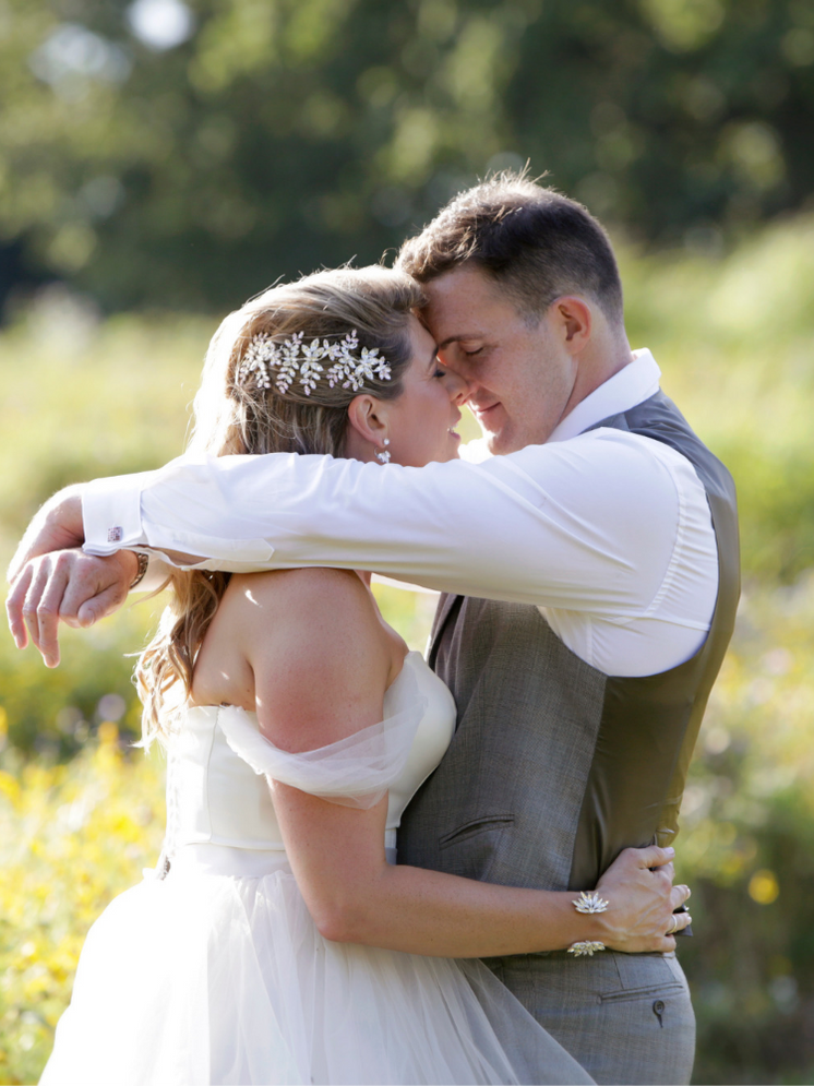 Bride and groom in wildflower meadow after their wedding at Coworth Park, Berkshire