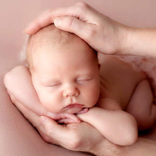 newborn girl in her parents' hands