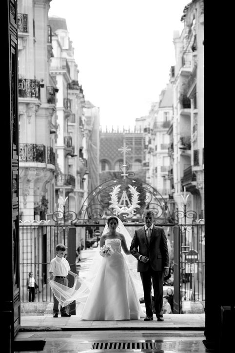 Bride and Father standing in the light of the church doors of Val-de-Grace, in Paris.