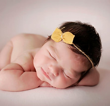 smiling richmond newborn girl with yellow bow