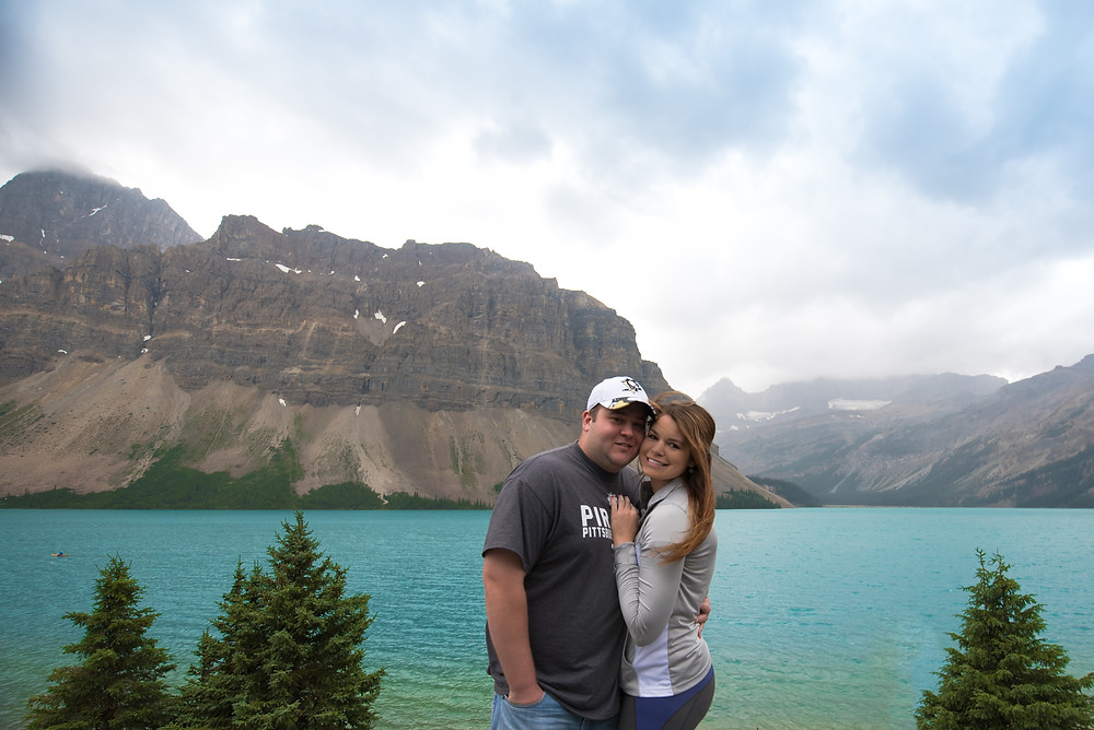 Photo of couple standing in front of Bow Lake in Alberta, Canada