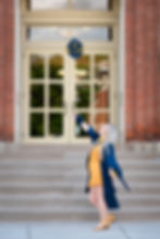 Girl throwing her blue graduation cap in the air at West VIrginia University