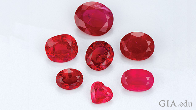 A collection of rubies from various origins, displaying a range of rich red hues, shapes, and sizes, highlighting the unique color variations and characteristics typical of different geographic sources.