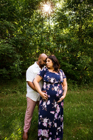 Maternity session, couple standing together, husband behind wife, heads together, hands on pregnant belly, Langworthy Park, AB