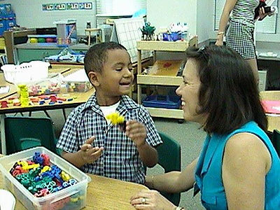 A young, elementary school age Maxwell talking to his teacher