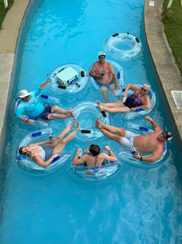 Group of guests floating on inner tubes down the Lazy River at Auburn RV Park