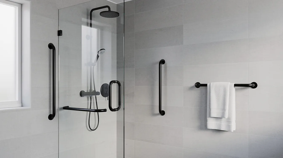 The image features a modern bathroom showcasing matte black grab rails installed next to a sleek glass shower screen, which harmonizes with the black shower fixtures and towel rail. This design not only enhances the aesthetic appeal but also provides essential support and increased safety for elderly users in wet areas.