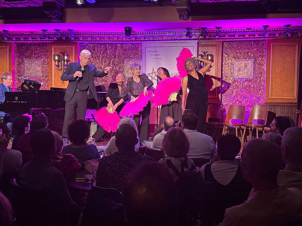 James Naughton speaks at 54 Below during the Chicago 50th Anniversary event, while original cast members perform with bright pink feather fans, adding flair to the classic number.
