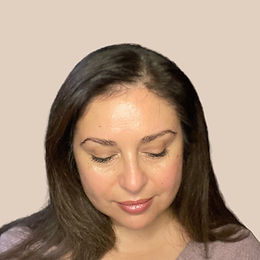 Julia Cantu, founder of Julia Cantu Skincare, looking down in natural light.