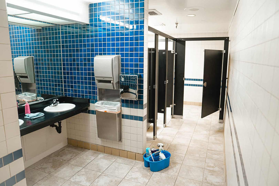 Commercial bathroom with stalls and cleaning equipment.jpg